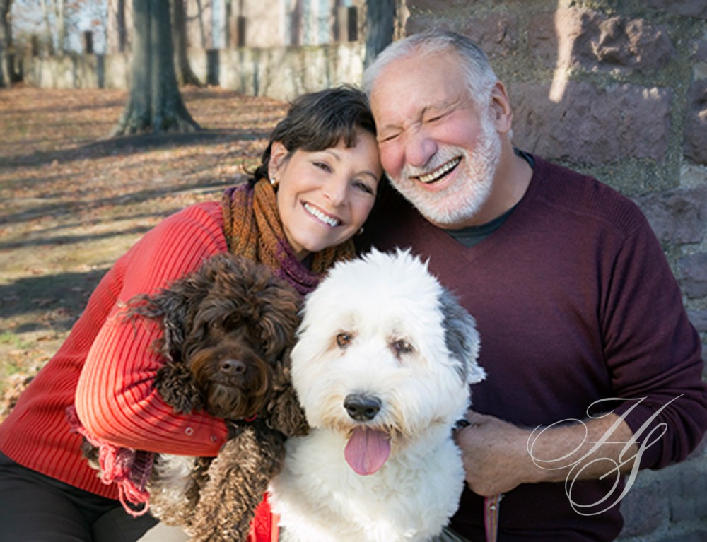 A man and woman with their dog in the park.