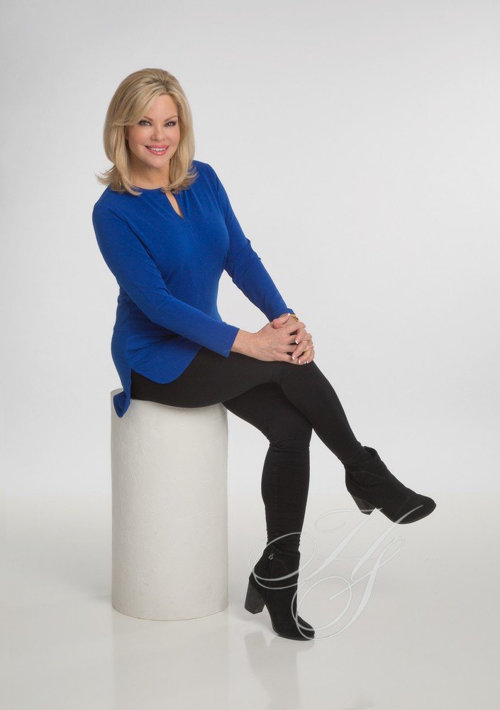 A woman sitting on top of a white cylinder.