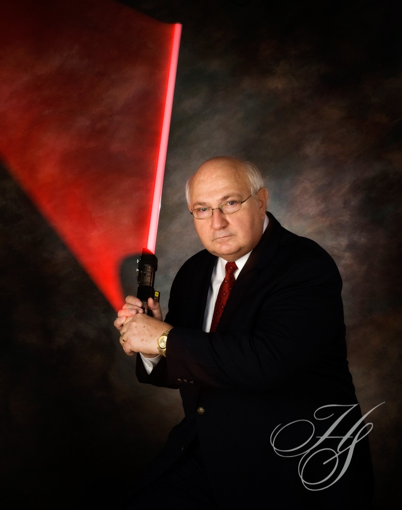 A man holding a baseball bat with a red light shining on it.