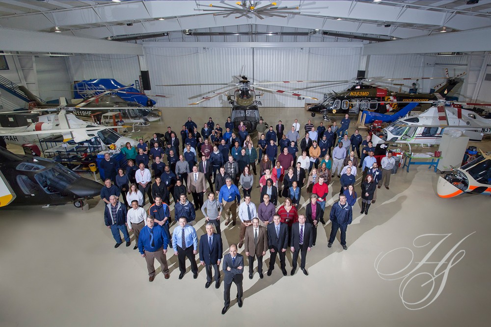 A group of people standing in an airplane hangar.