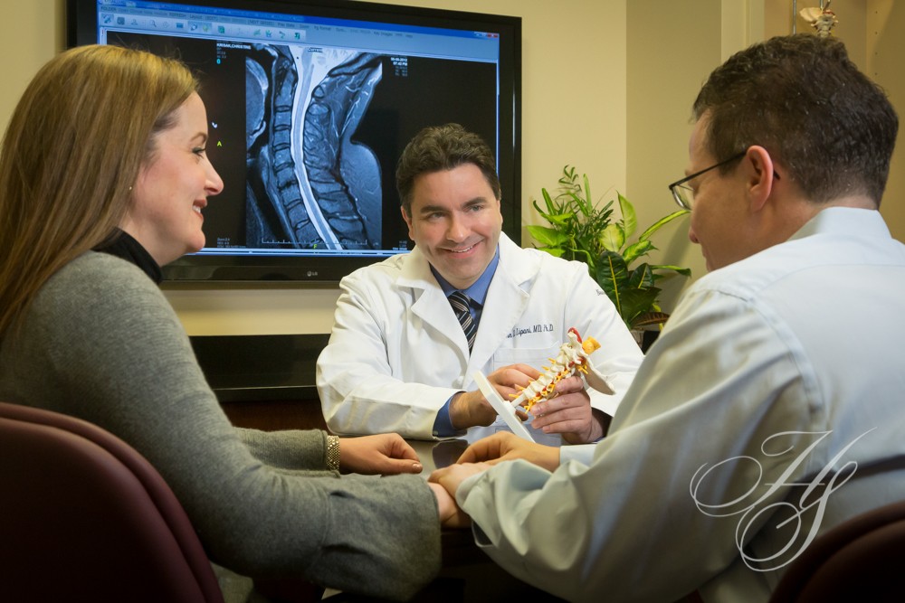A doctor and two other doctors sitting in front of a tv.