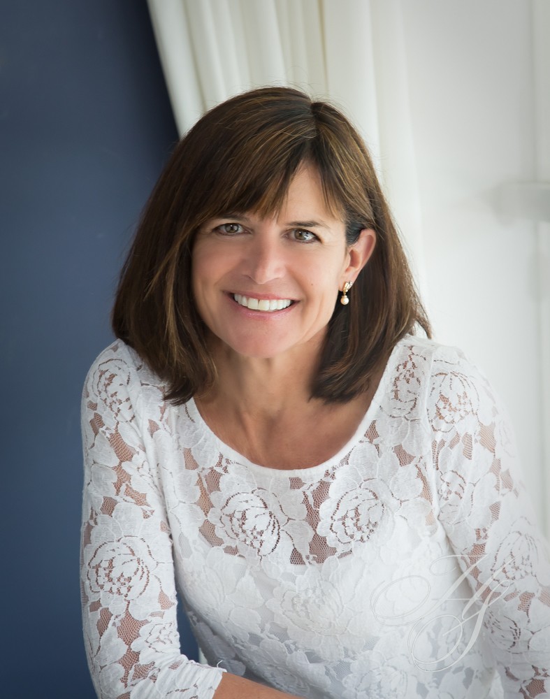 A woman in white shirt smiling for the camera.