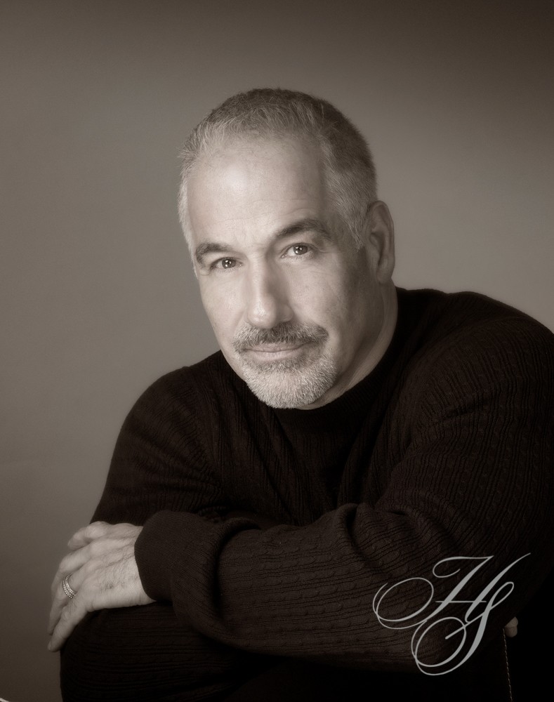A man with his arms crossed posing for the camera.