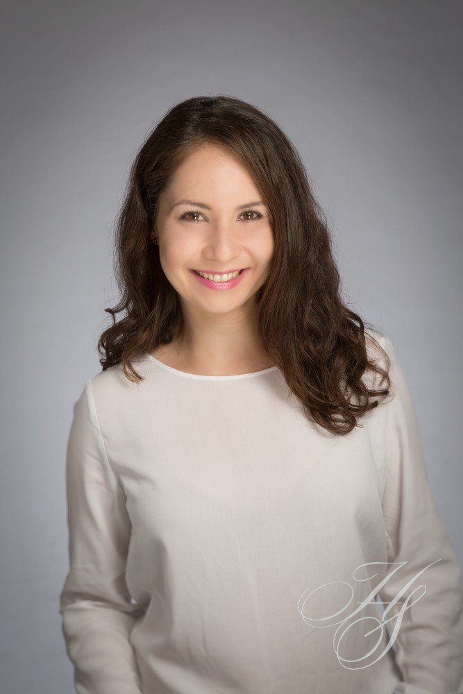 A woman in white shirt smiling for the camera.