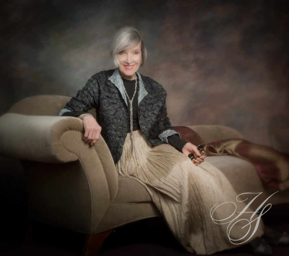 A woman sitting on top of a chair in front of a wall.