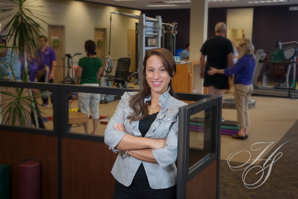 A woman standing in an office with people in the background.