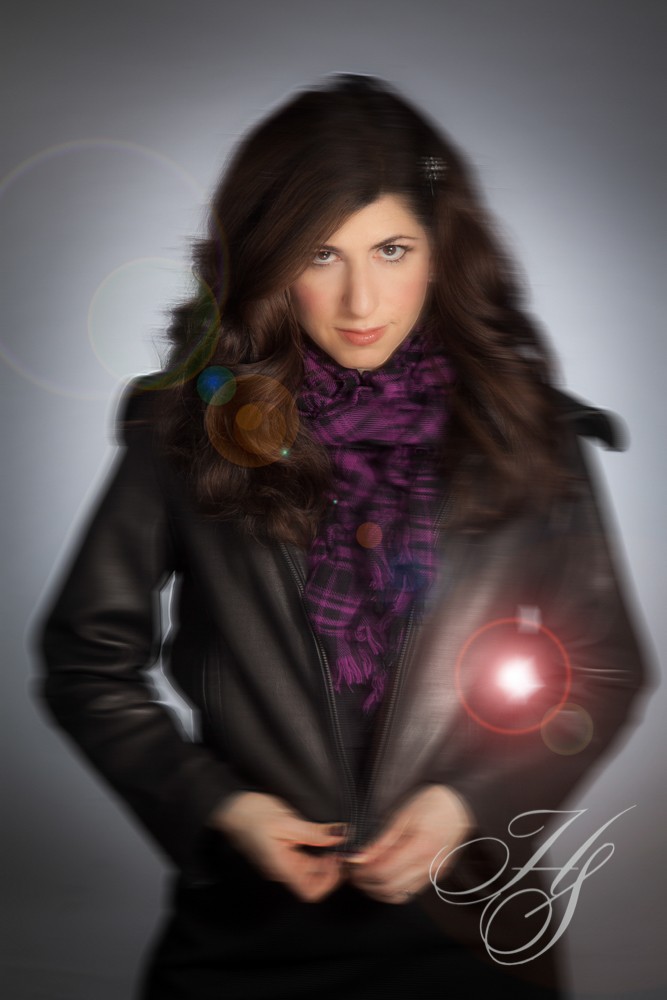 A woman in black jacket and purple scarf.