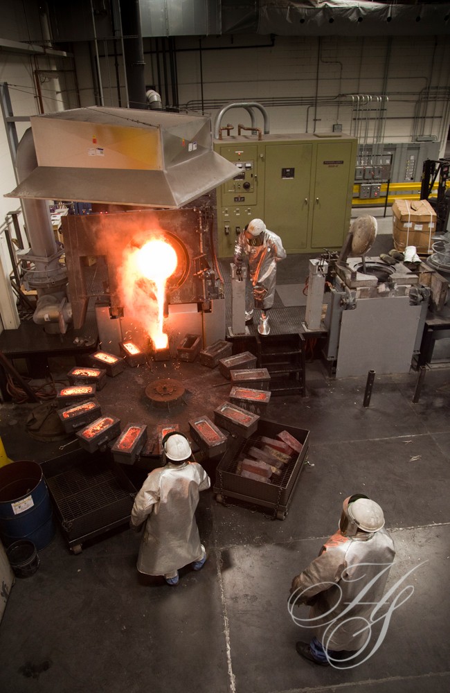 A group of people in white coats working on an object.