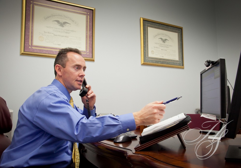 A man sitting at his desk talking on the phone.
