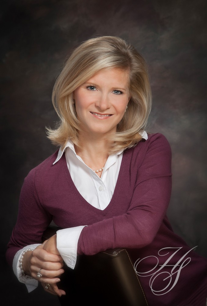A woman in a purple sweater posing for a picture.
