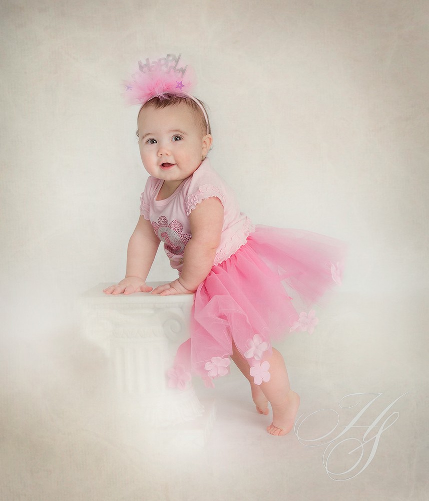 A baby girl in pink tutu and headband.
