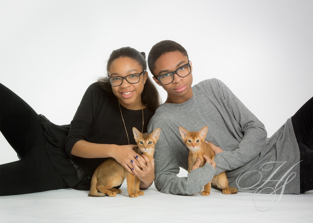 Two people and a cat pose for the camera.