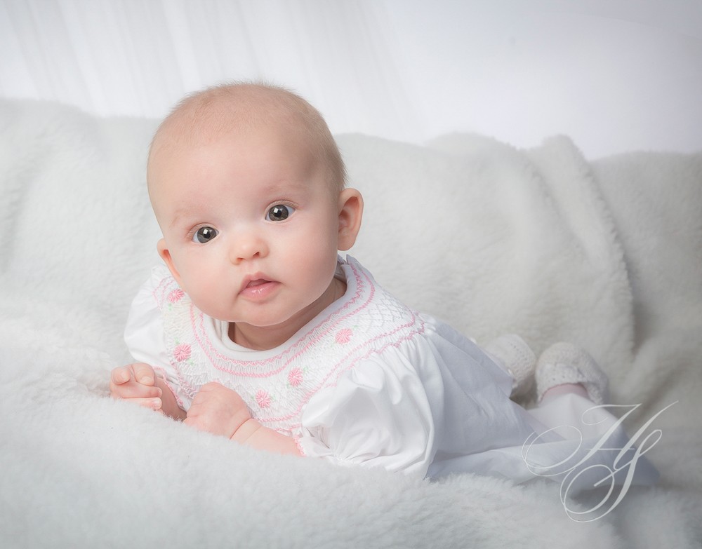 A baby is laying down on the bed