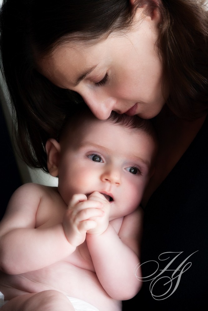 A woman holding onto the head of a baby