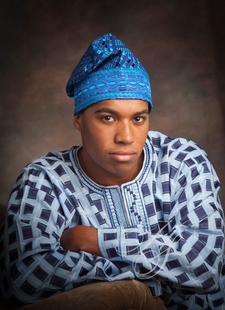 A man in blue and white outfit with his arms crossed.