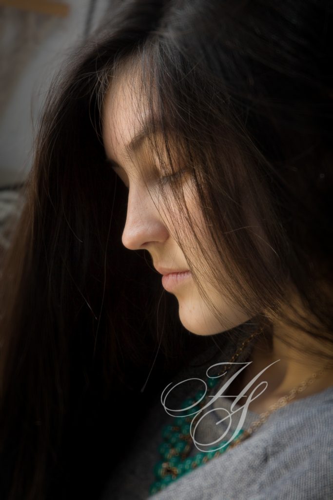 A woman with long hair is looking down.