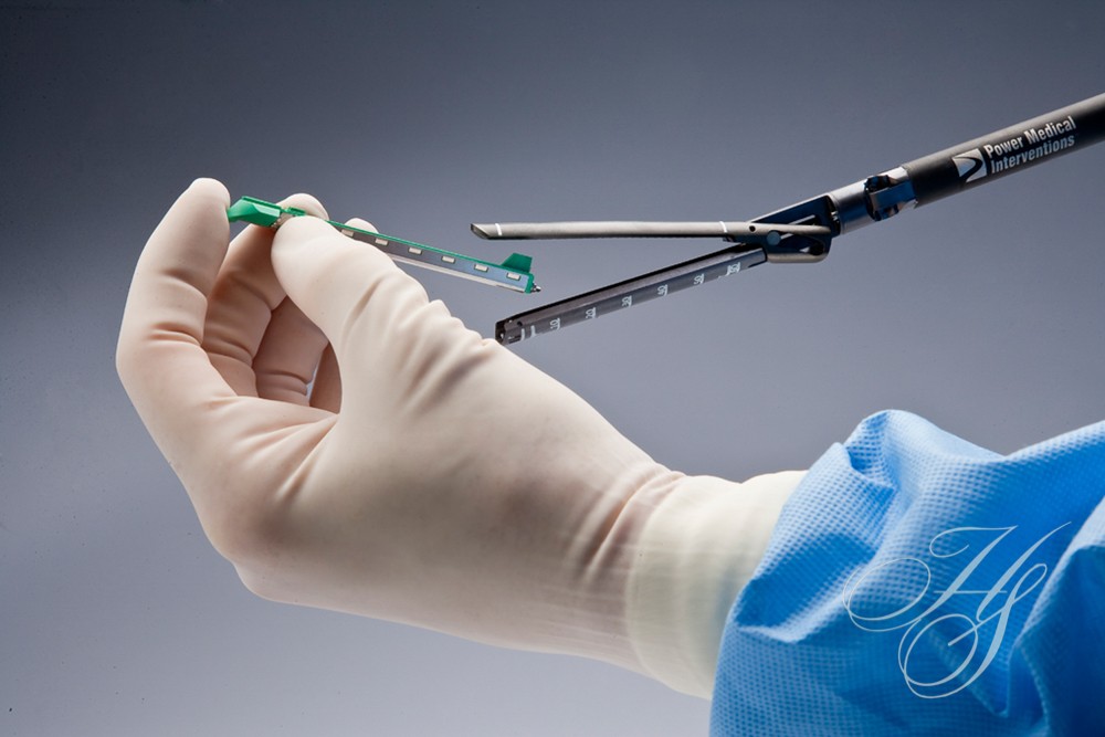 A surgeon holding two surgical instruments in his hand.