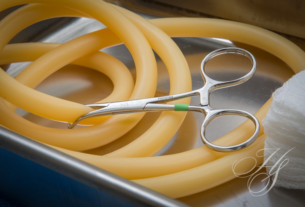 A pair of scissors sitting on top of some yellow tubing.
