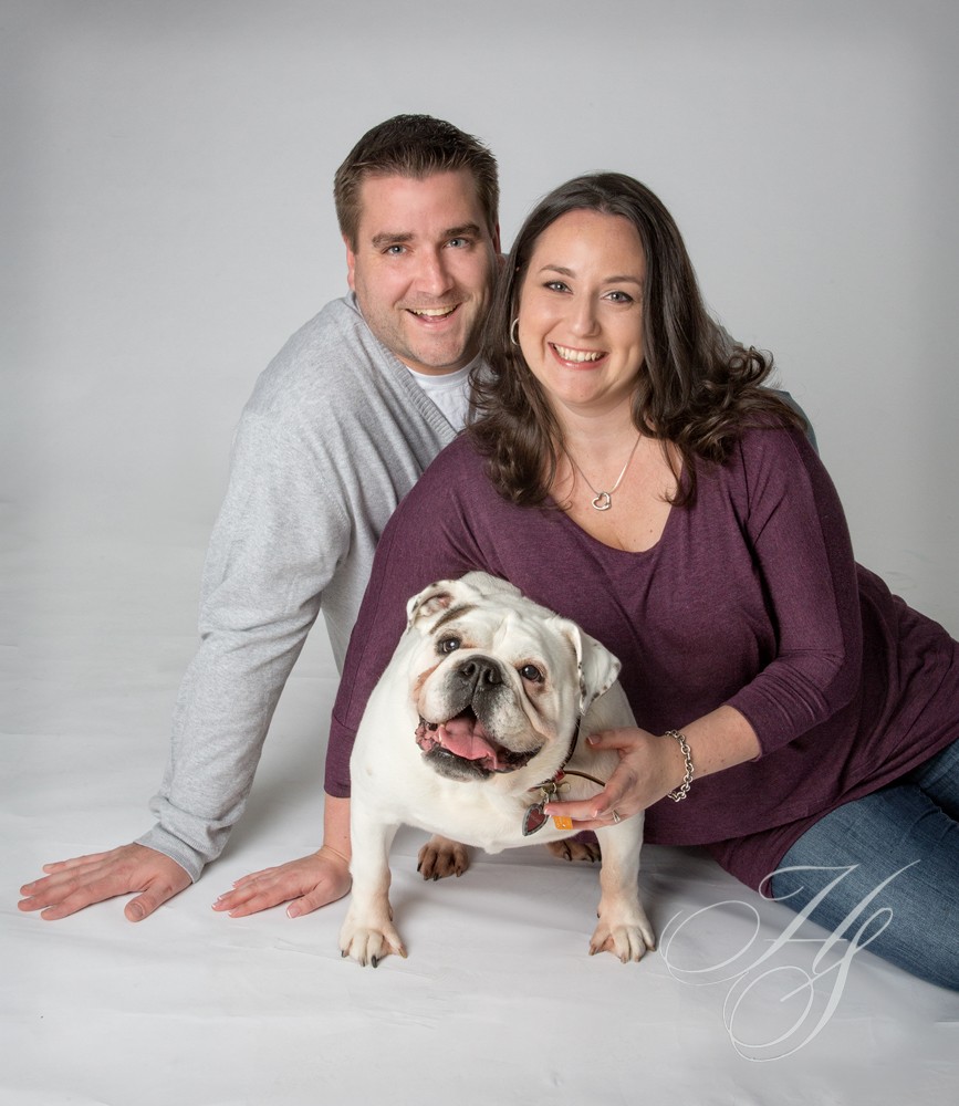 A man and woman posing with their dog.