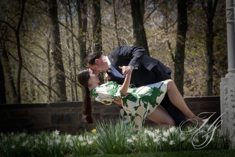 A man and woman kissing in the grass.