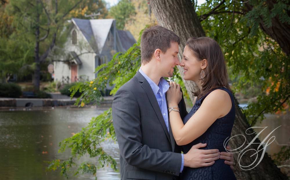 A man and woman kissing in front of a tree.