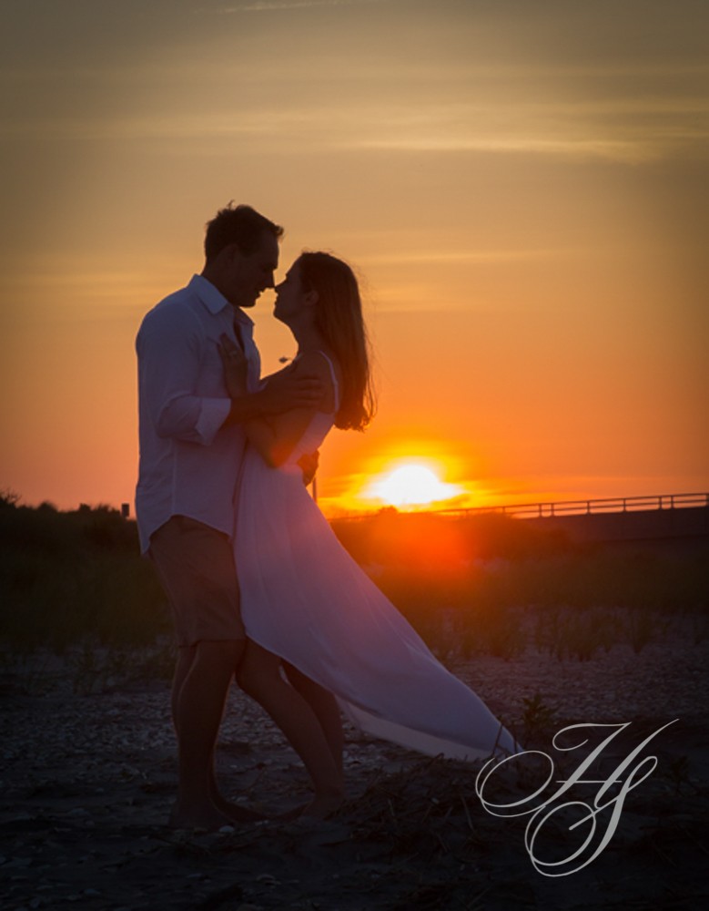 A man and woman are dancing on the beach.