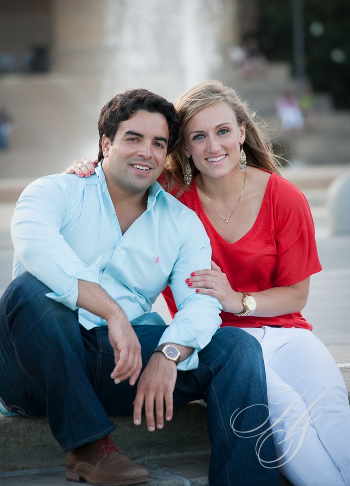 A man and woman sitting on steps smiling for the camera.
