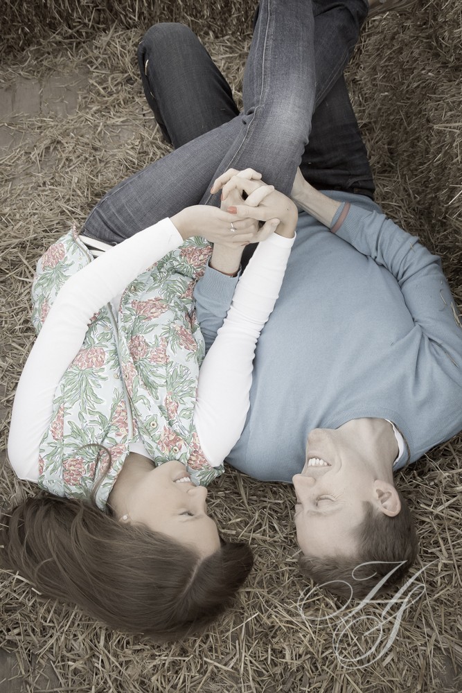 Two people laying on the ground looking at a phone