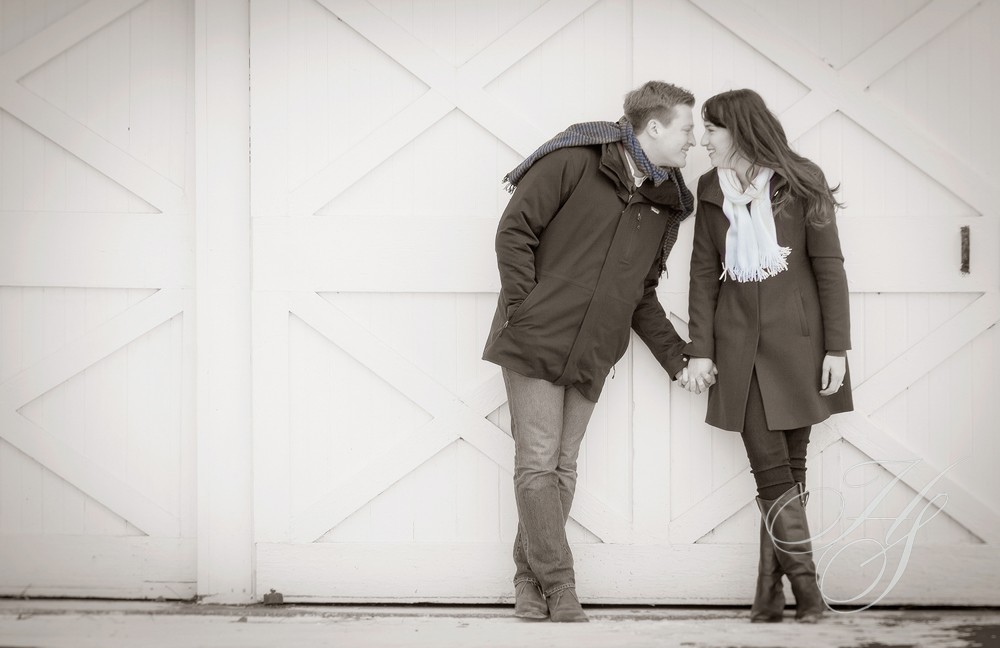 A man and woman kissing in front of a white door.