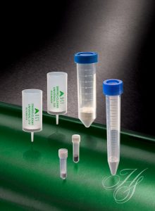 A green table with some plastic tubes and a blue cap