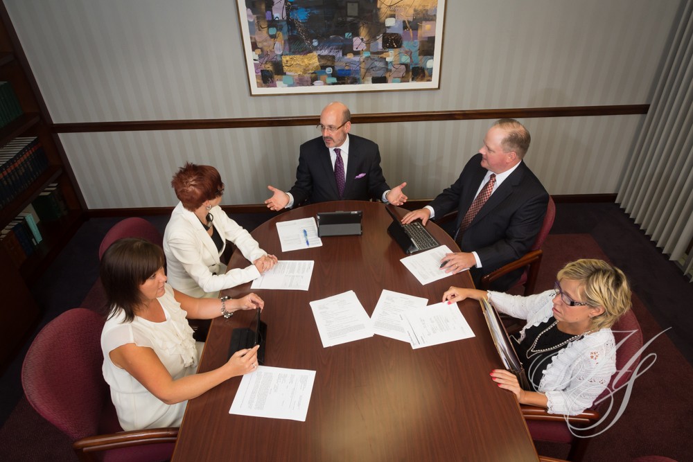 A group of people sitting at a table with papers.