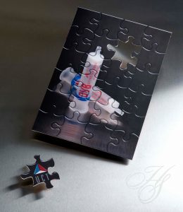 A puzzle with a candle on it next to a missing piece.