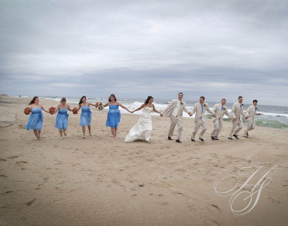 A group of people on the beach holding hands.