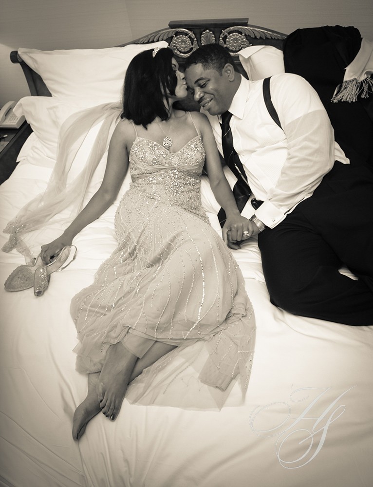 A man and woman sitting on top of a bed.
