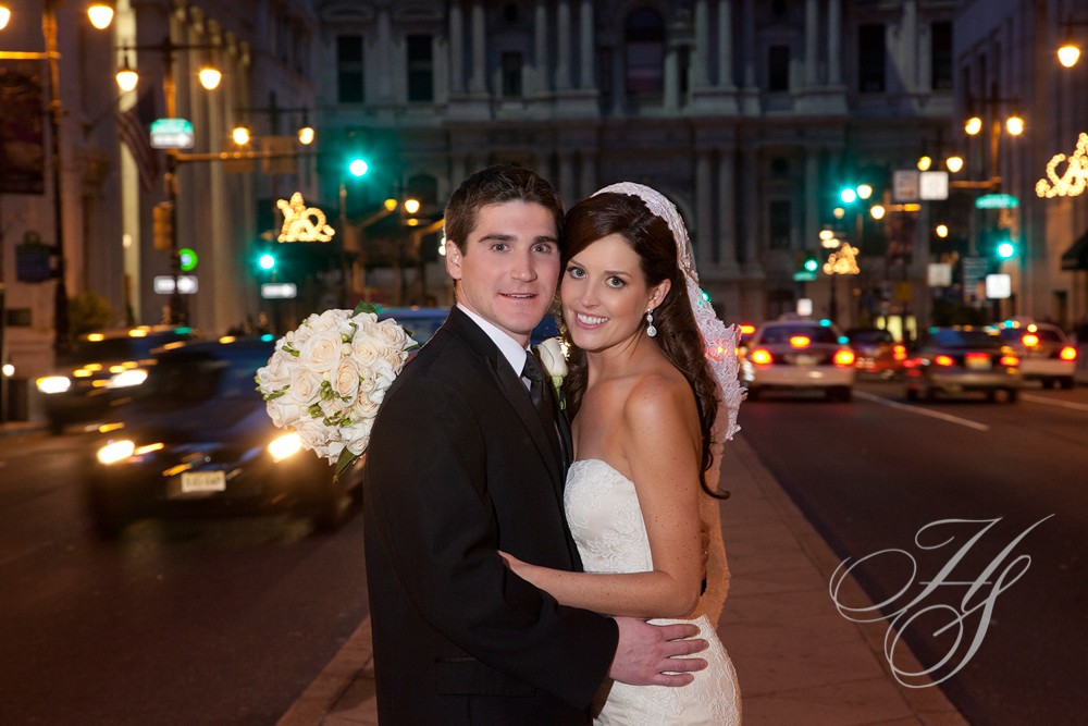 A bride and groom pose for the camera on their wedding day.