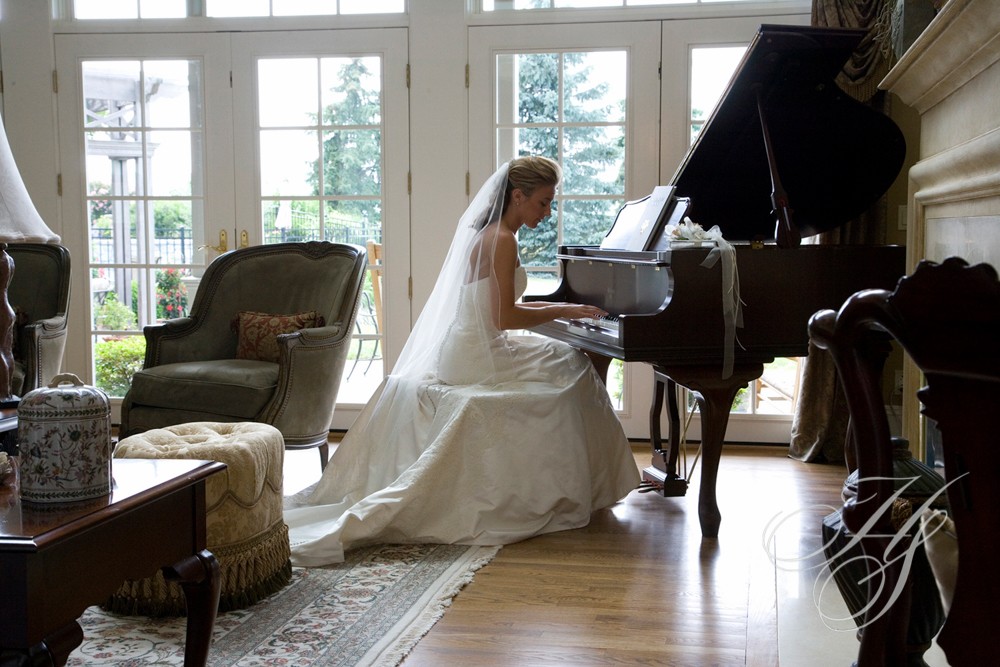 A bride in her wedding dress playing the piano