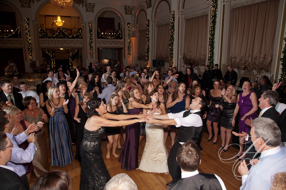 A group of people dancing in front of many other people.