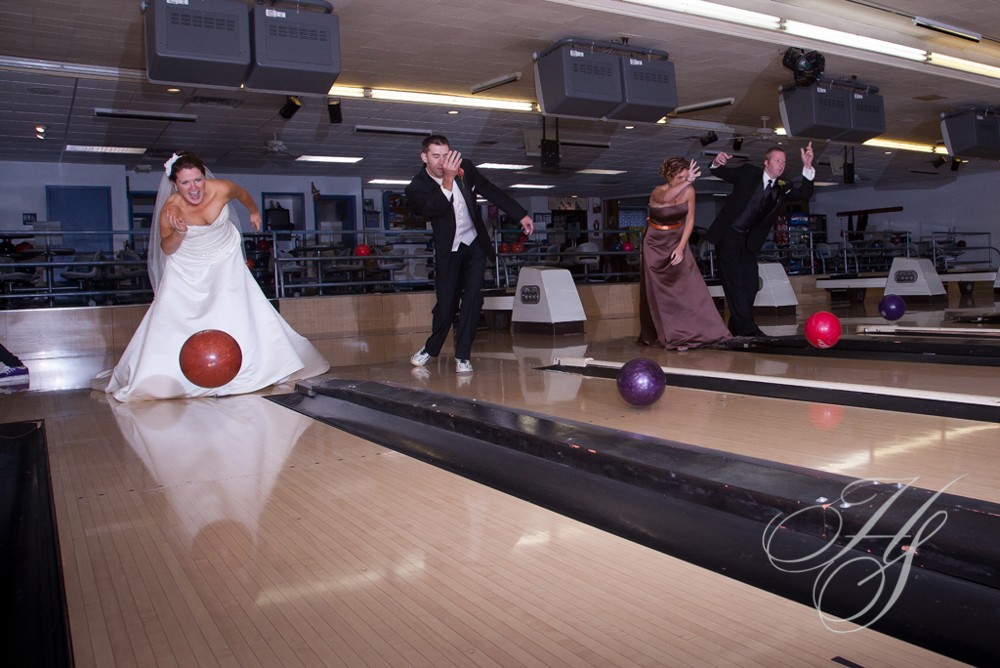 A group of people standing around bowling alley.