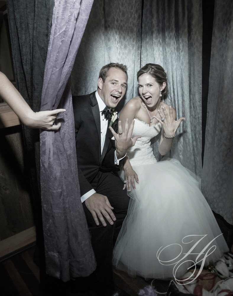 A bride and groom posing for a picture in the photo booth.