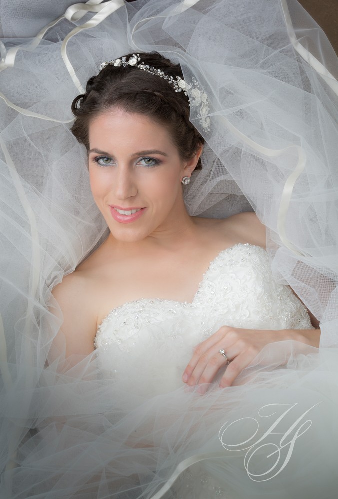 A bride in her wedding dress posing for the camera.