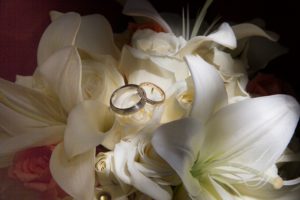 A close up of two wedding rings on top of flowers
