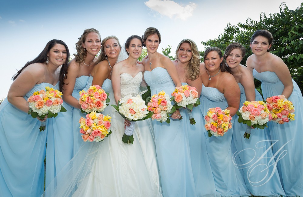 A group of women in blue dresses holding flowers.