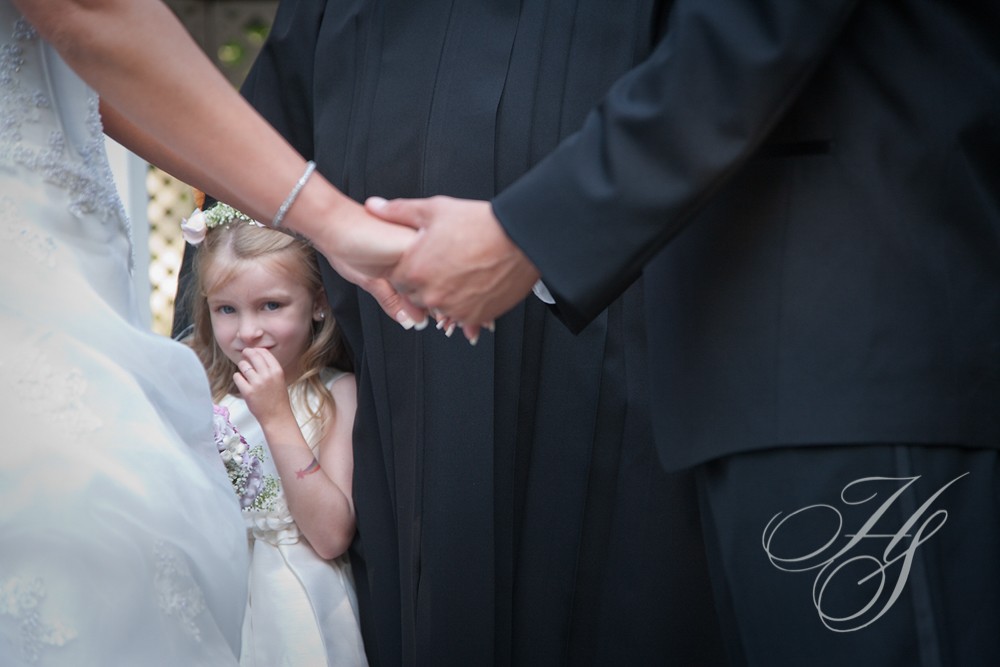 A little girl looks at the bride and groom.