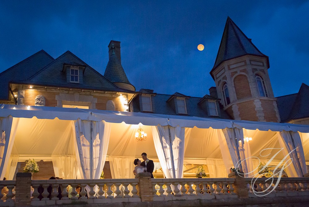 A couple standing on the balcony of their wedding venue.