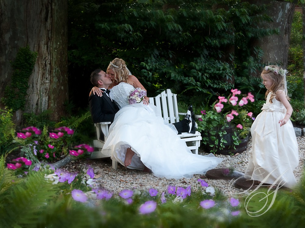 A bride and groom kissing on the bench