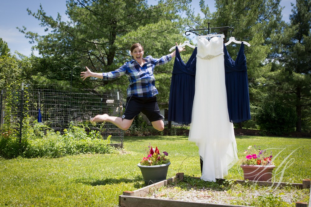 A man jumping in the air next to a dress.