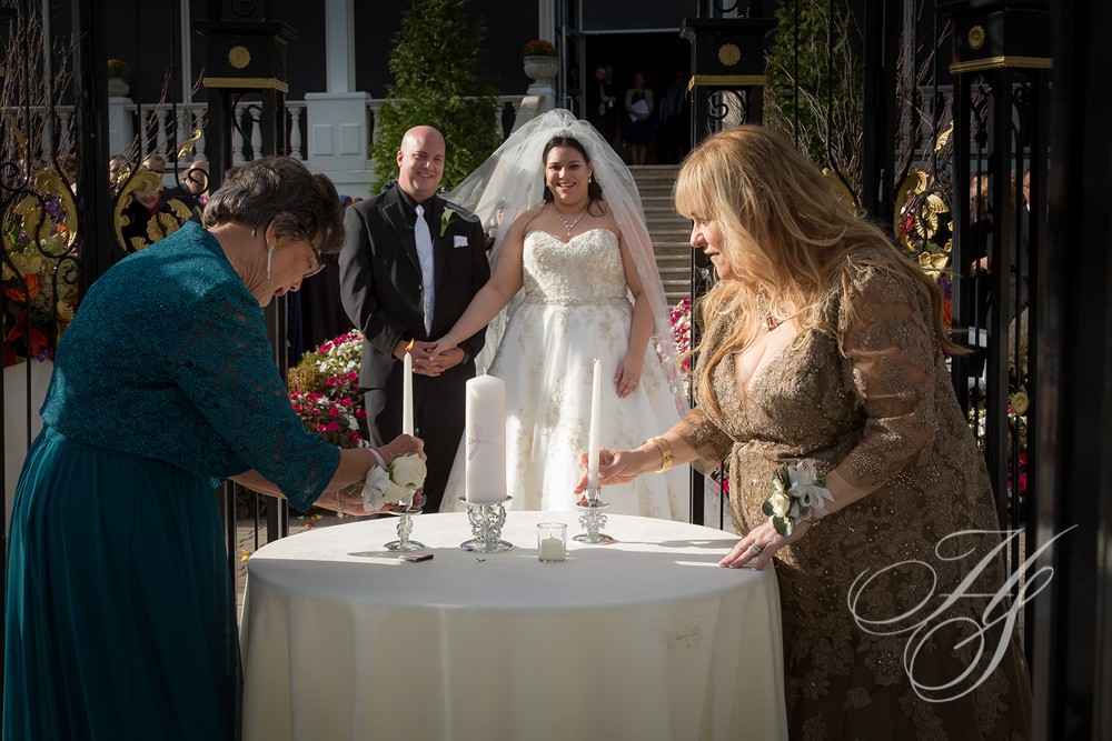 A woman lighting the candles on a wedding cake.