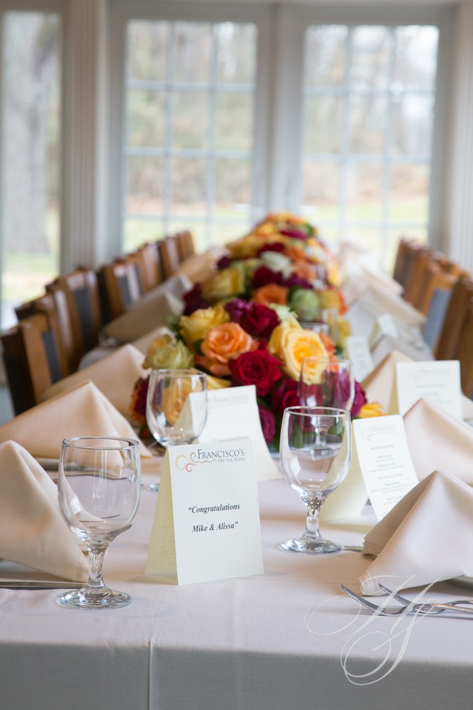 A long table with place settings and flowers.