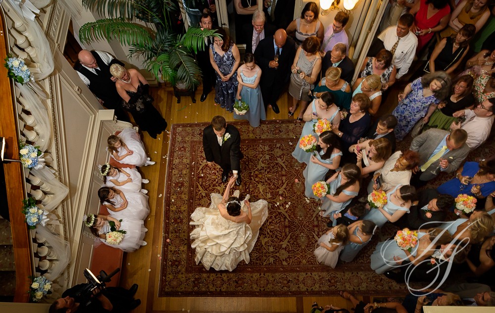 A bride and groom are standing in front of a crowd.