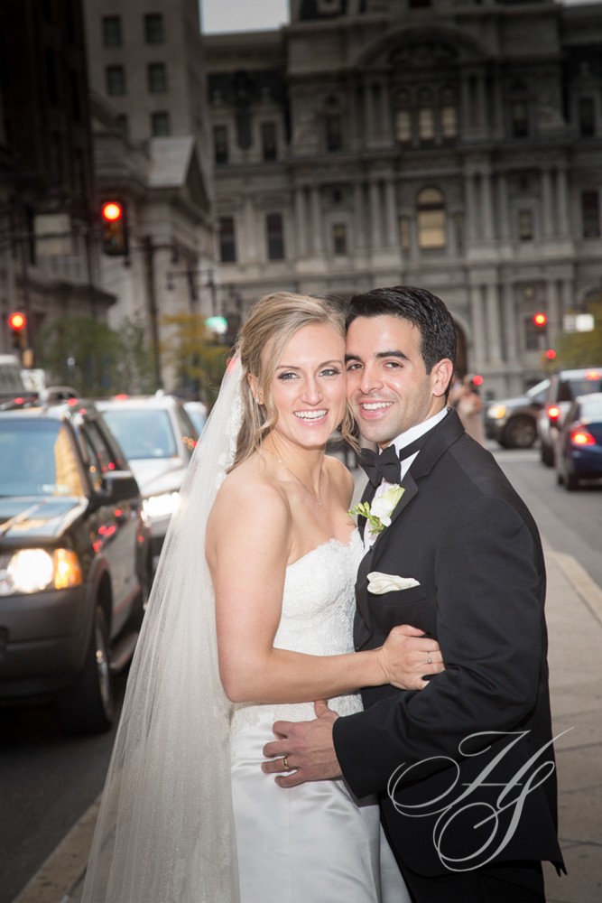 A bride and groom pose for the camera on their wedding day.